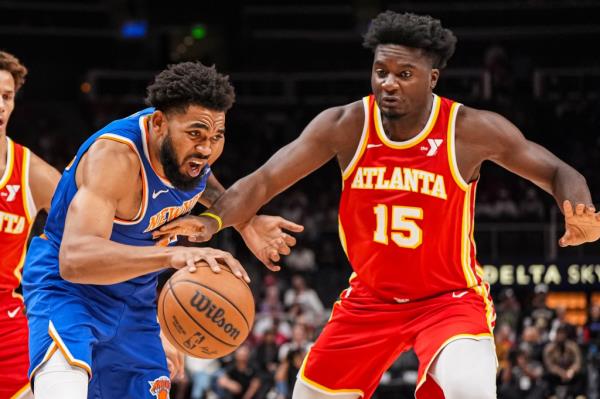 New York Knicks center Karl-Anthony Towns (32) dribbles Atlanta Hawks center Clint Capela (15) during the first half at State Farm Arena.