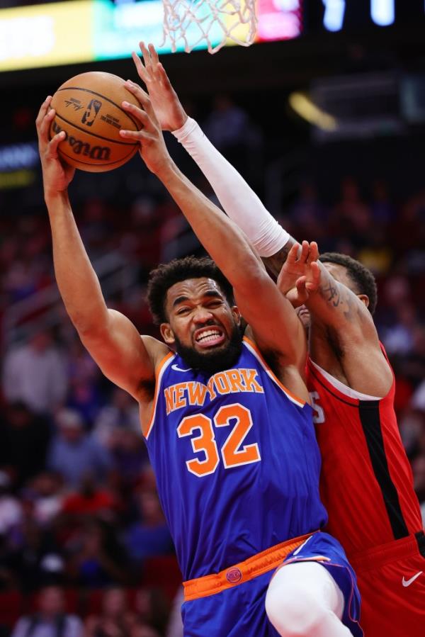 Karl-Anthony Towns #32 of the New York Knicks draws a foul from Jabari Smith Jr. #10 of the Houston Rockets during the first half at Toyota Center on November 04, 2024 in Houston, Texas. 