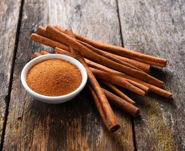 Cinnamon powder and sticks on wooden table