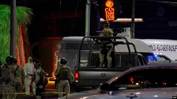 Mexican Army soldiers and a forensic expert stand guard outside the Los Cantaritos bar wher<em></em>e an armed group broke in on the eve, killing ten people and leaving at least seven more injured, in the city of Queretaro, state of Queretaro, Nov. 10, 2024.