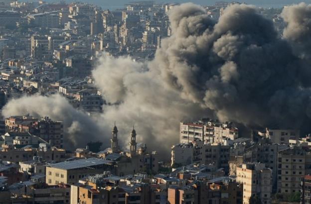 Smoke billows over buildings.