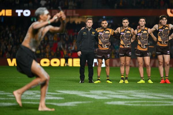 The Hawthorn team watches on during a pre-game Indigenous ceremony